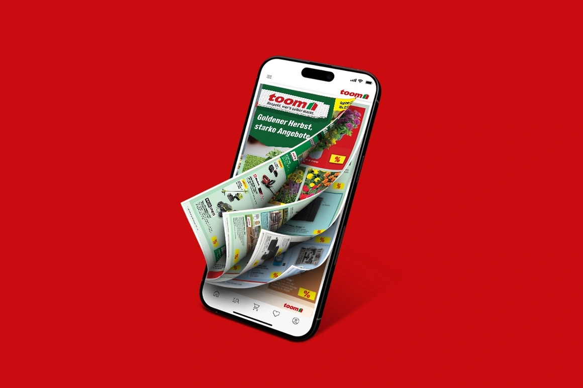 Ein Smartphone auf rotem Hintergrund zeigt den toom Prospekt